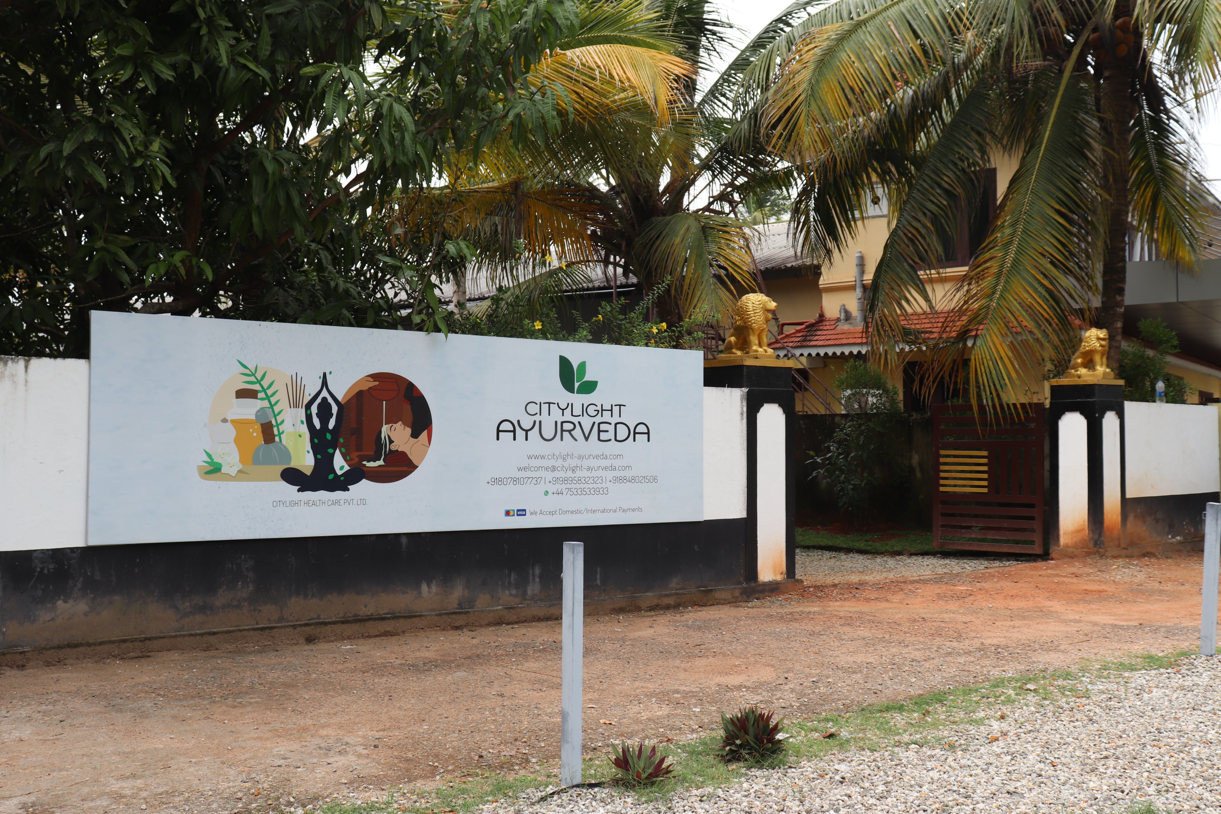 Entrance area with Ayurveda sign and palm trees